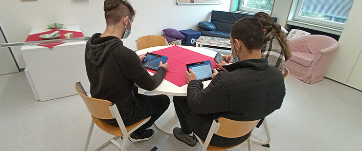 Drei Personen mit Tablets an einem Tisch. Foto: Winfried Altmann